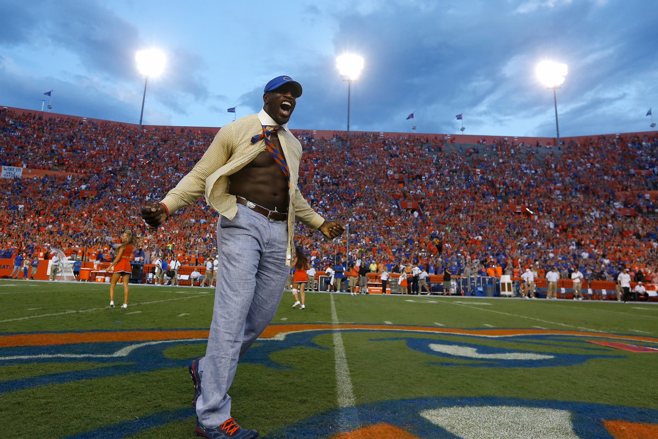 Titus O'Neil wears the signature yellow button up and seersucker pants of UF's Mr. Two-bits while running onto the UF football field