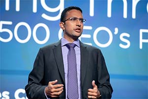 This is a photo of a man who is standing before a screen and speaking.