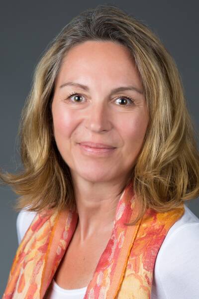A headshot of a woman with a gray background.