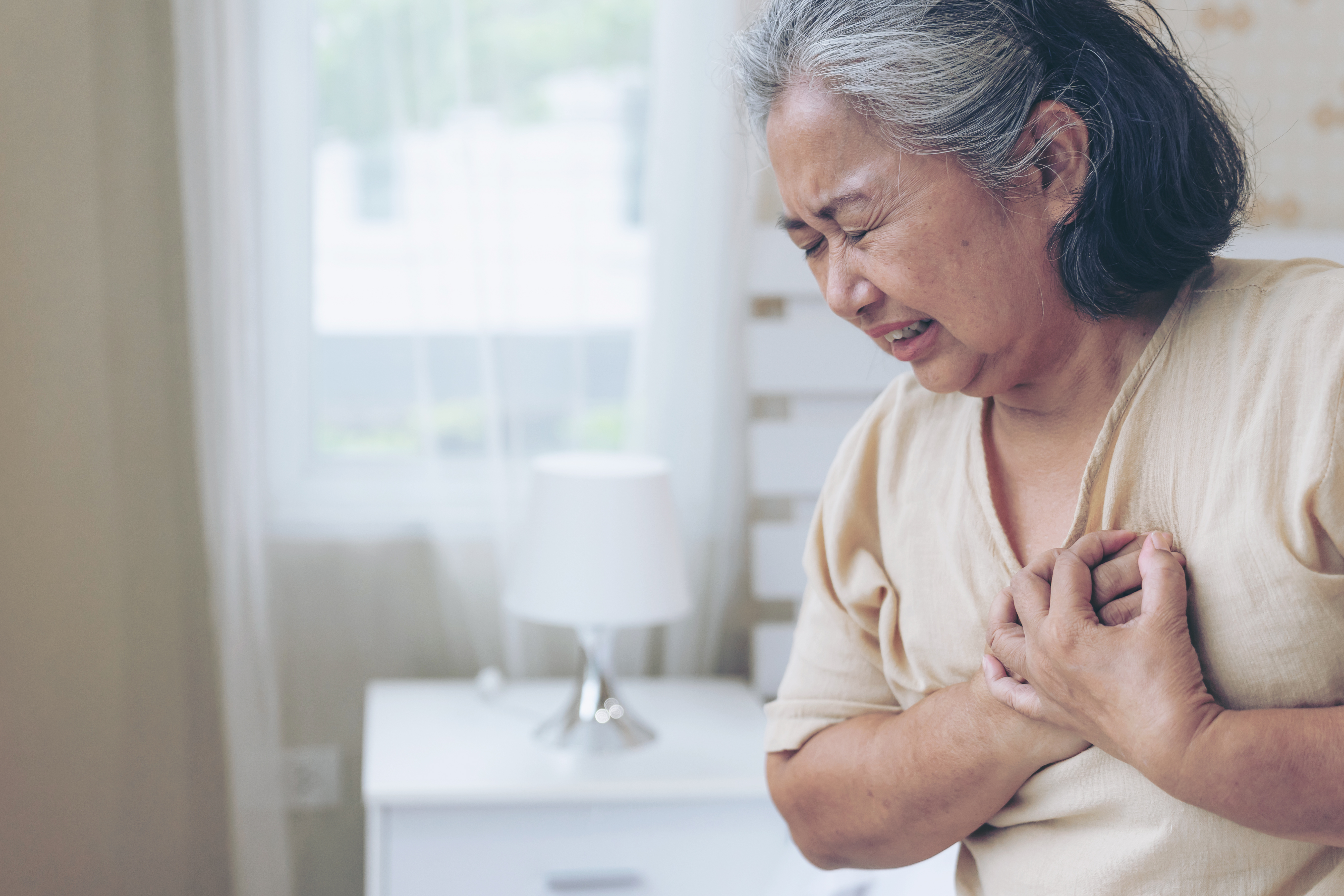 A woman clutching her chest in pain