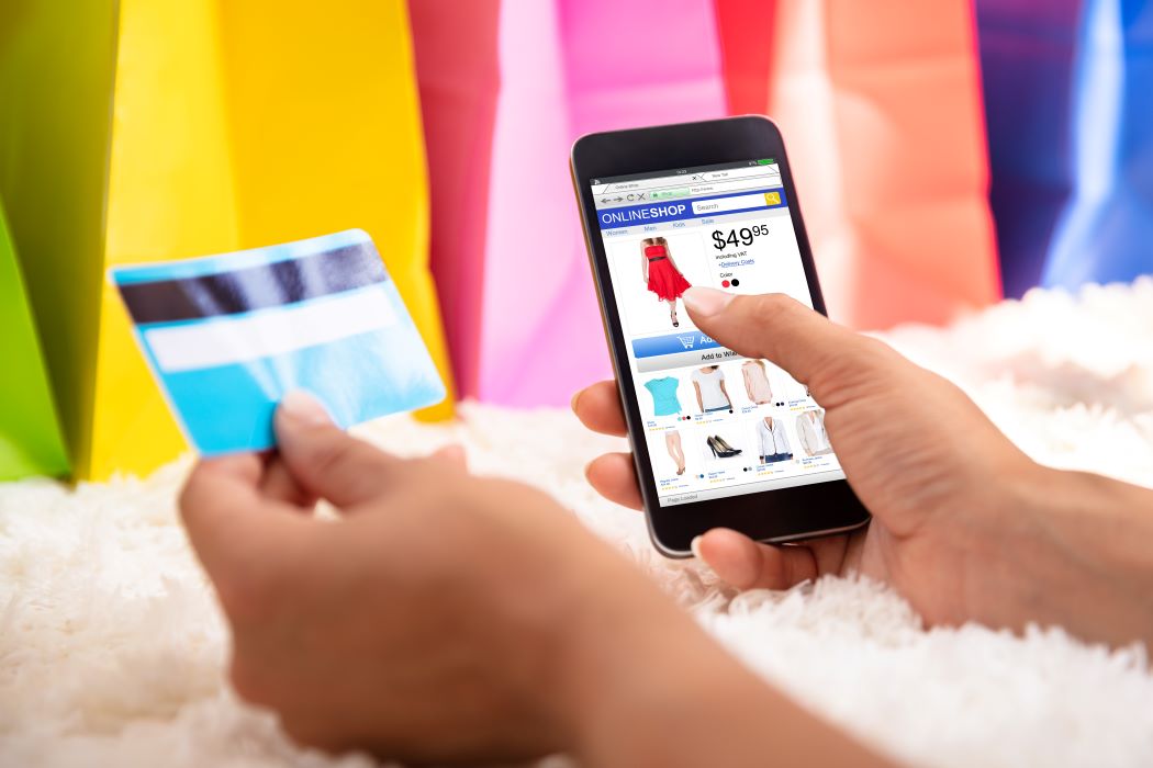 A woman's hands holding a smartphone and a credit card.