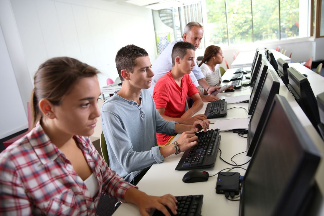 students at long desk working on computers