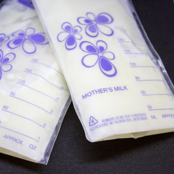 Two full bags of stored breast milk on a table