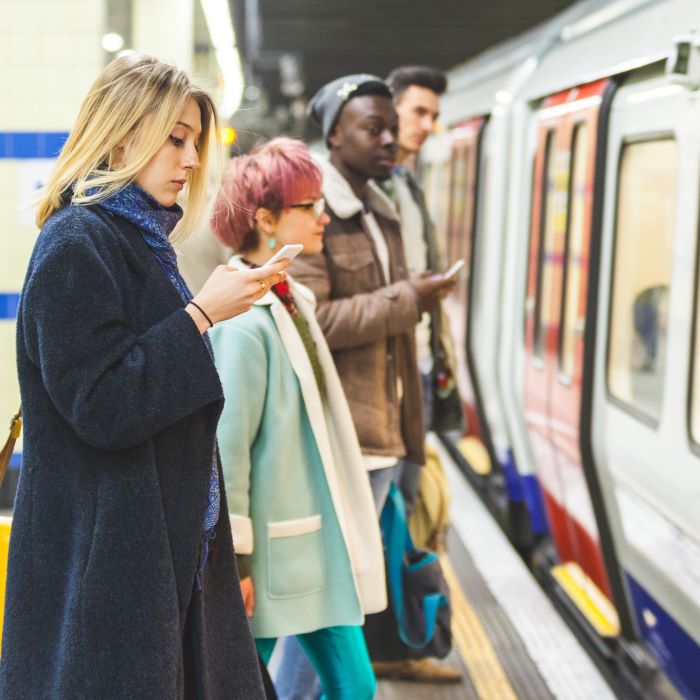 Several people waiting on a platform as a subway train arrives