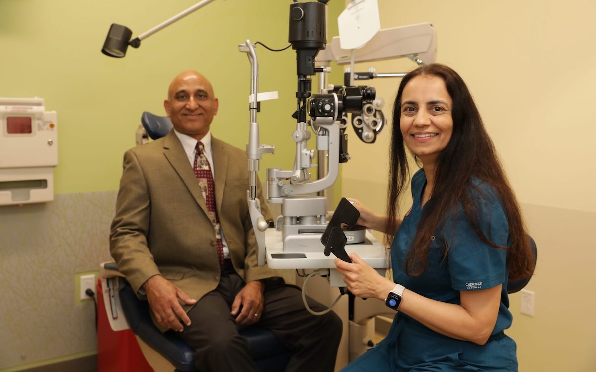A staged photo of a female giving an eye exam to a male patient.