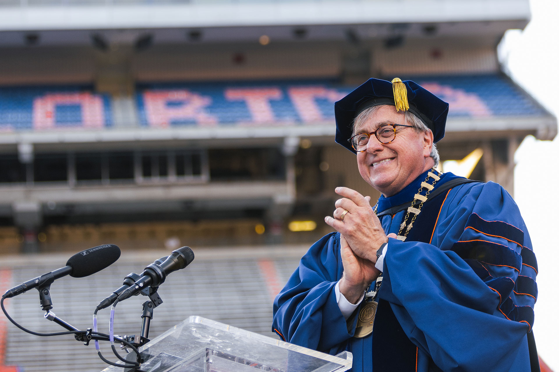 A man speak stands before a podium