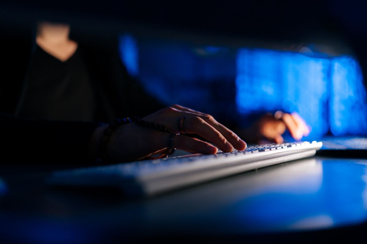 close up of hands on a computer keyboard in the dark
