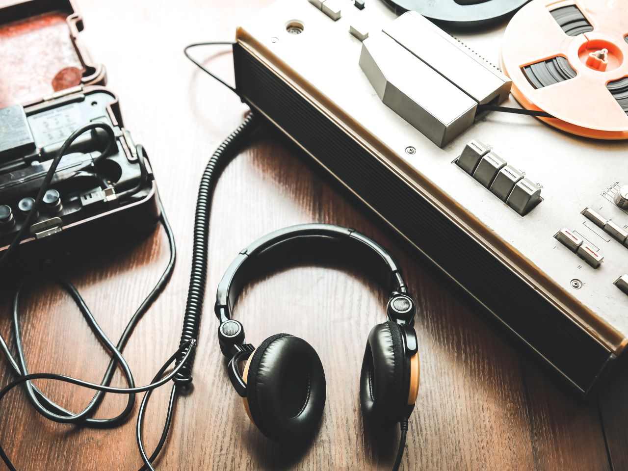 A pair of headphone attached to a reel-to-reel tape player