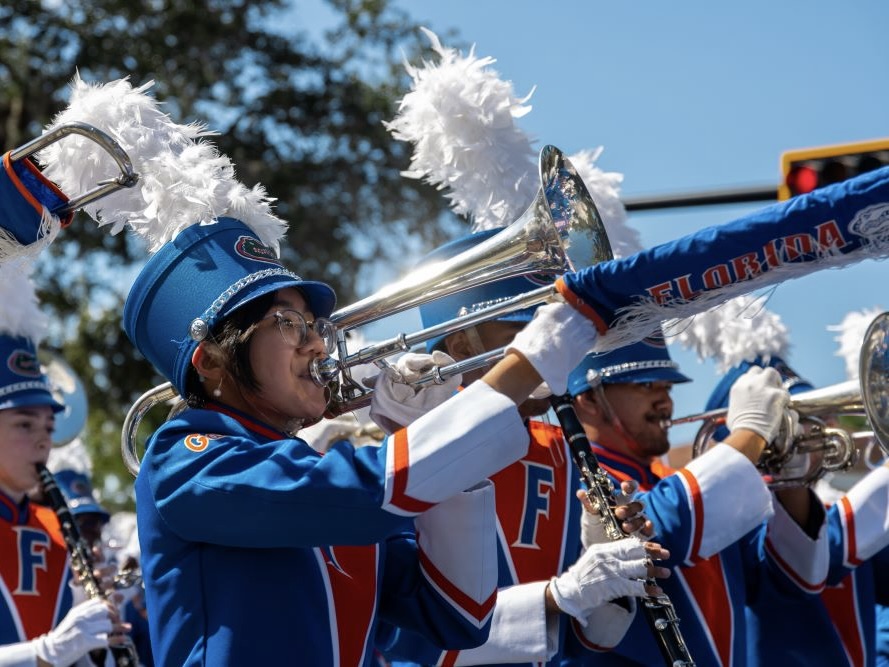 A band member playing an instrument in the UF Homecoming parade.