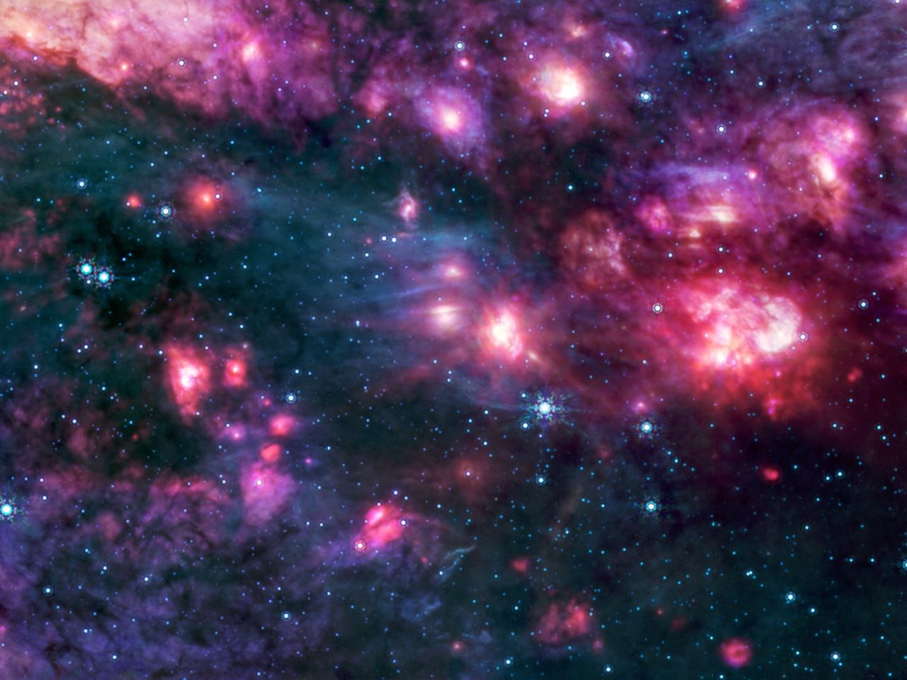 A telescopic image of a star forming nebula showing many white stars surrounded by blue and purple gas