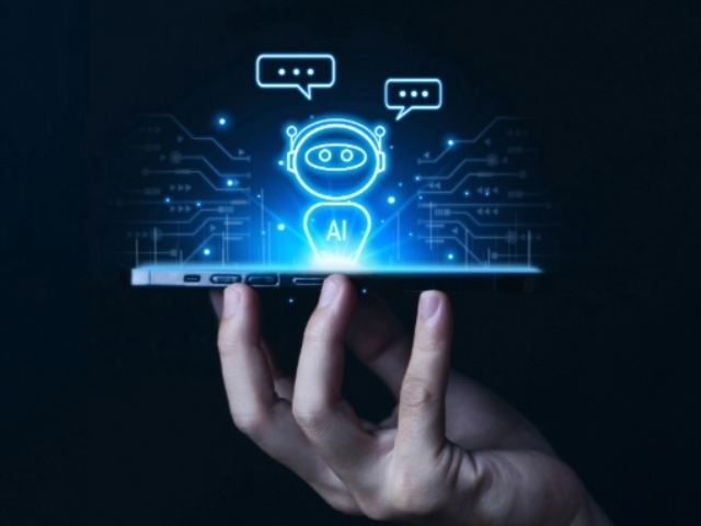 A stock image of a robot hologram on a phone being held up by fingers.