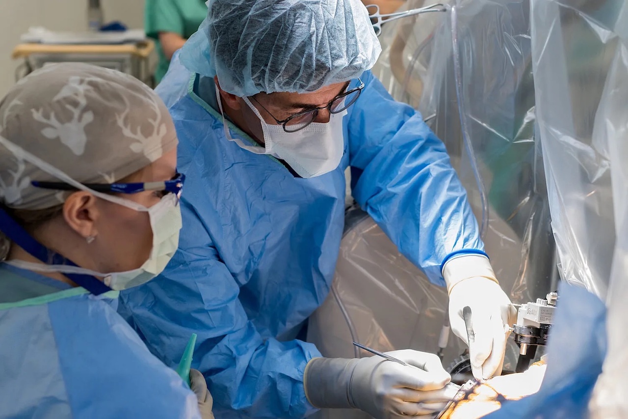 Two surgeons in scrubs operate on a patient